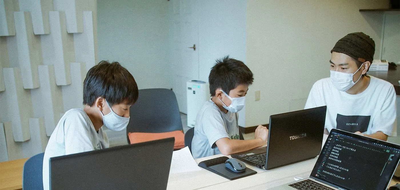 生徒3人に講師1人までの少人数授業。画面を見ながら教える講師と生徒たち